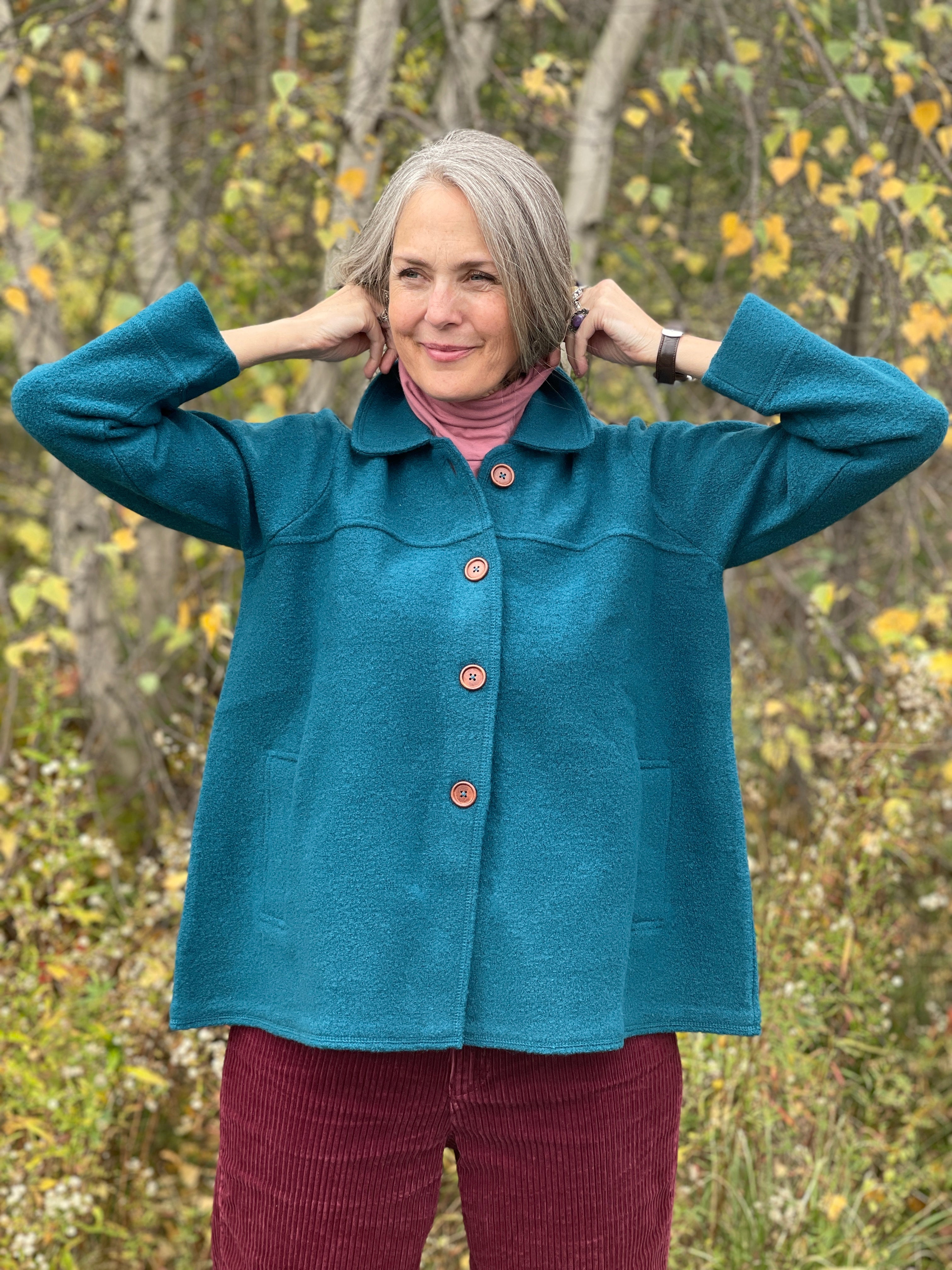 Woman in Blue boiled wool swing coat standing in snow 